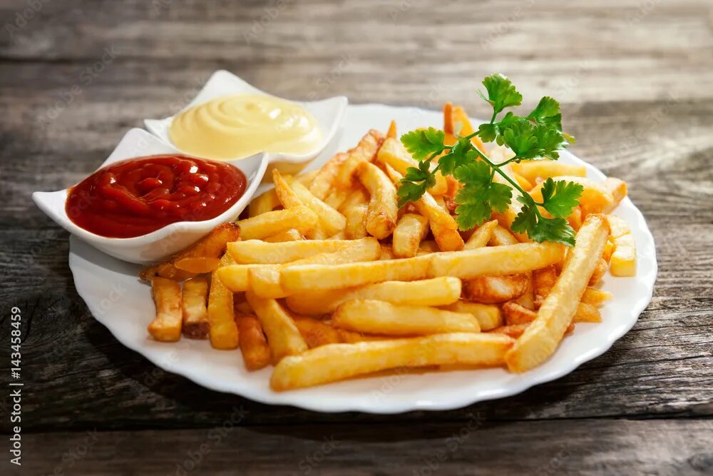 Картошка фри с соусом фото French fries with tomato sauce, mayonnaise and parsley фотография Stock Adobe St