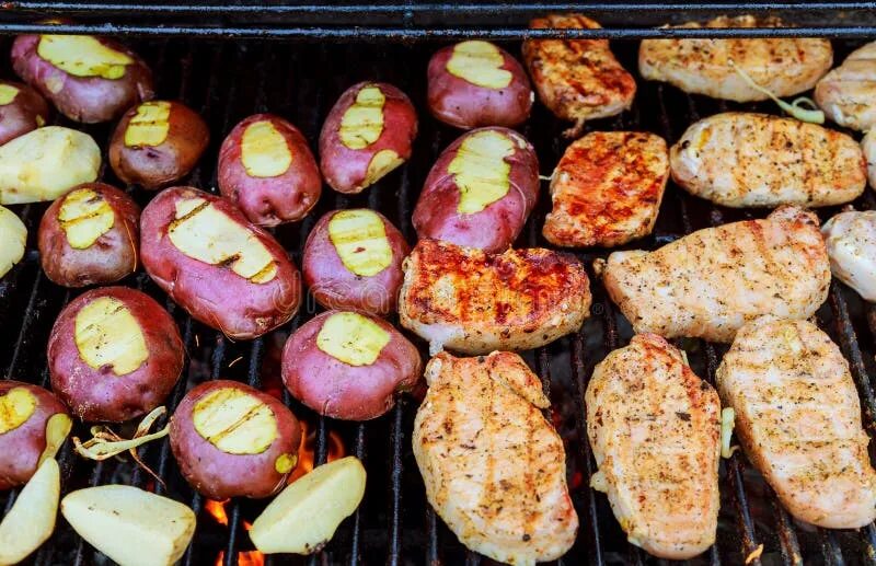 Картошка на решетке на фото Weekend. Skewers with Pieces of Sausages, Onions, Peppers are Cooked on a Grate 