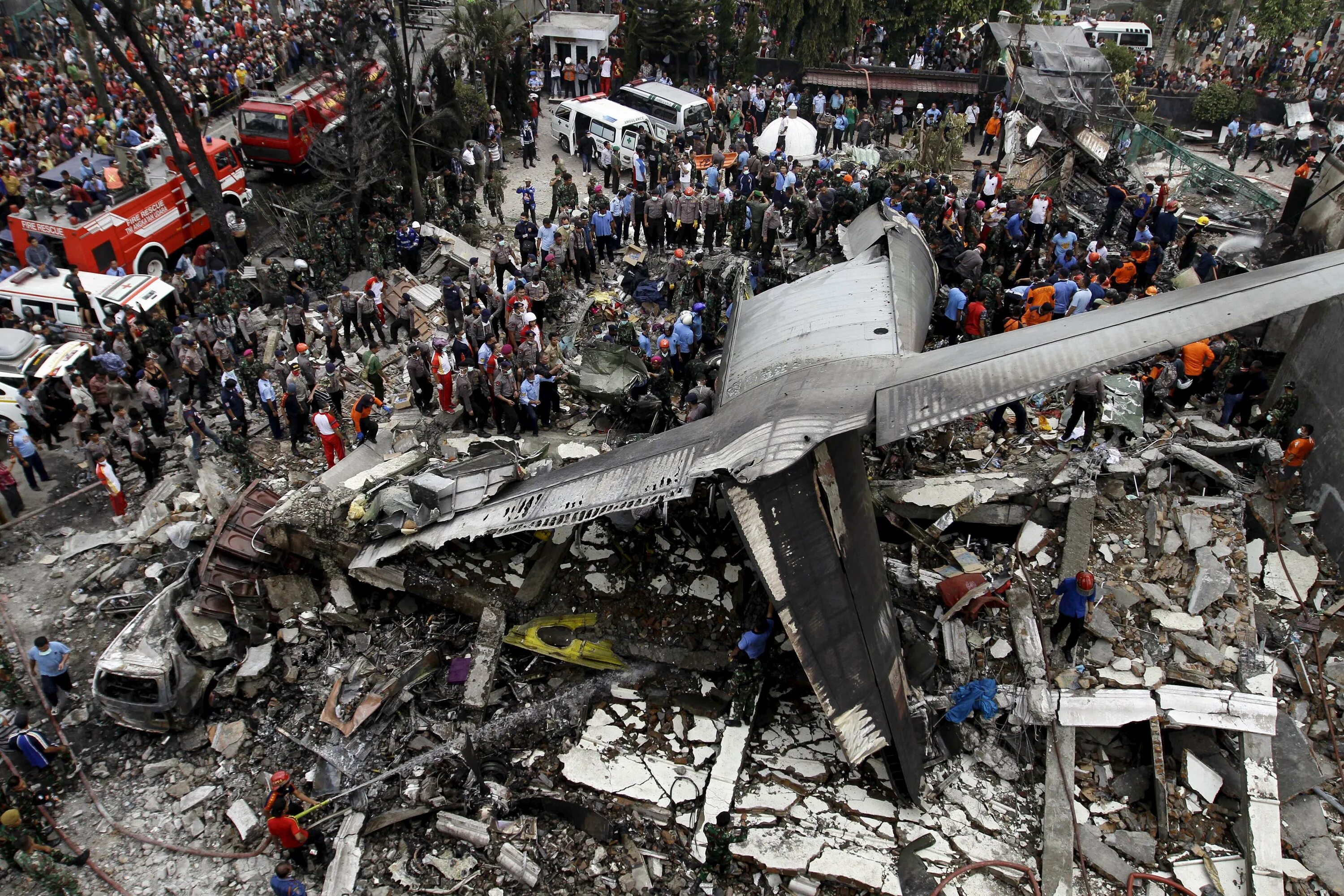 Катастрофы самолетов фото Security forces and rescue teams examine the wreckage of an Indonesian military 