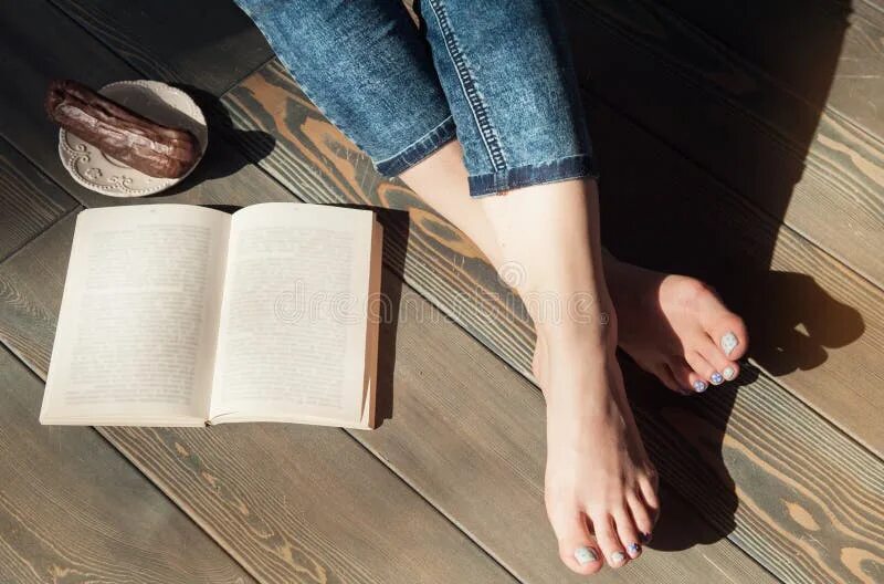 Книга стоп фото Cozy Photo of Young Woman Feet with Book and Cake on the Floor Stock Image - Ima