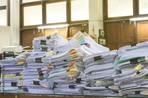 Куча бумаг на столе фото Pile of documents on desk stack up high waiting to be managed. - Buy this stock 