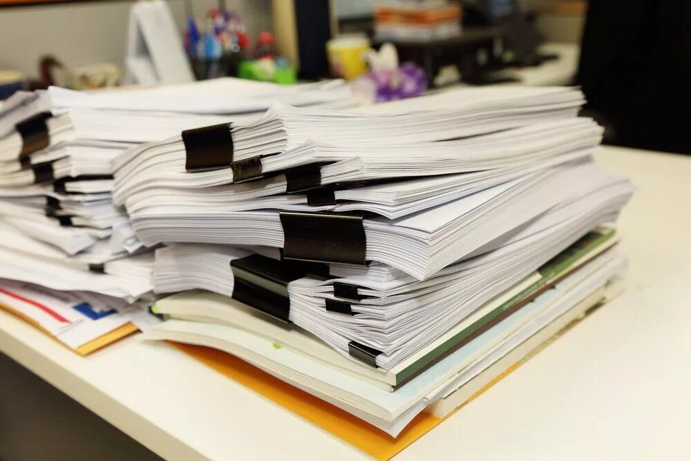 Куча бумаг на столе фото Власти Чувашии не смогли закупить офисную бумагу