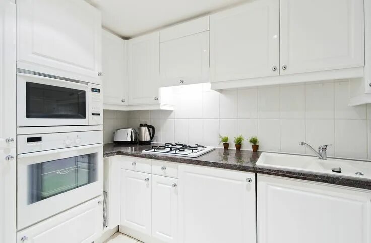 Кухня с белой техникой в интерьере фото L-Förmige Einbauküche mit dunkler Steinarbeitsplatte Kitchen, Kitchen splashback
