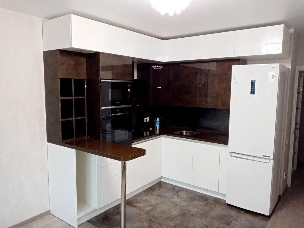 Кухонные гарнитуры студия фото Белая угловая кухня с барной стойкой от фабрики Кухни Премьер