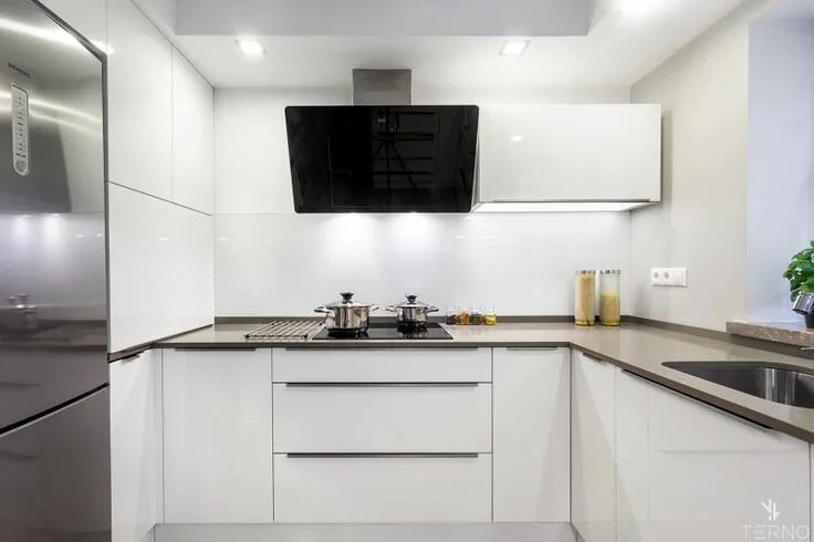 Кухонный гарнитур с вытяжкой фото П-образная белая кухня, с наклонной вытяжкой. Ручки - торцевые.