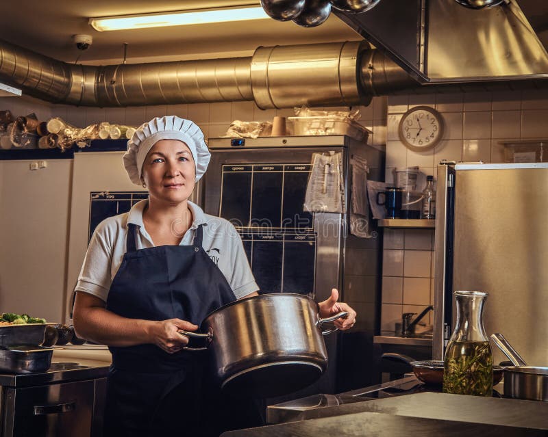 Кухонный работник фото Повар среднего возраста нося форму держа лоток на кухне ресторана Стоковое Фото 