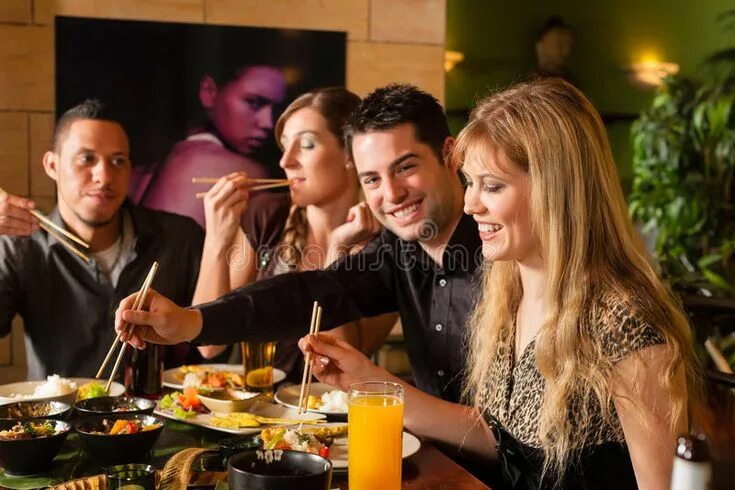 Кушать в ресторане фото Young people eating in Thai restaurant. Young people eating in a Thai restaurant