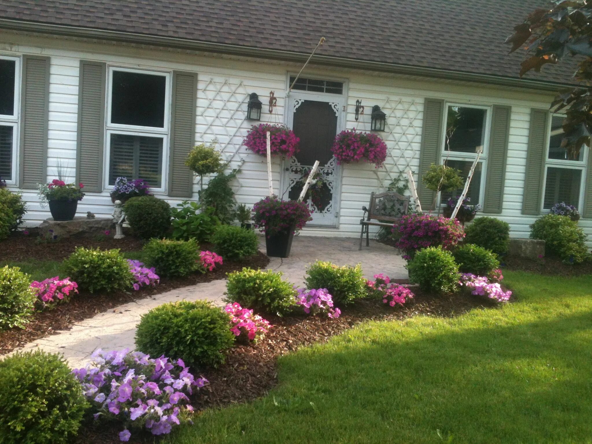 Квадратная клумба перед домом приемы оформления Winding path accented with inexpensive petunia hanging baskets planted between y