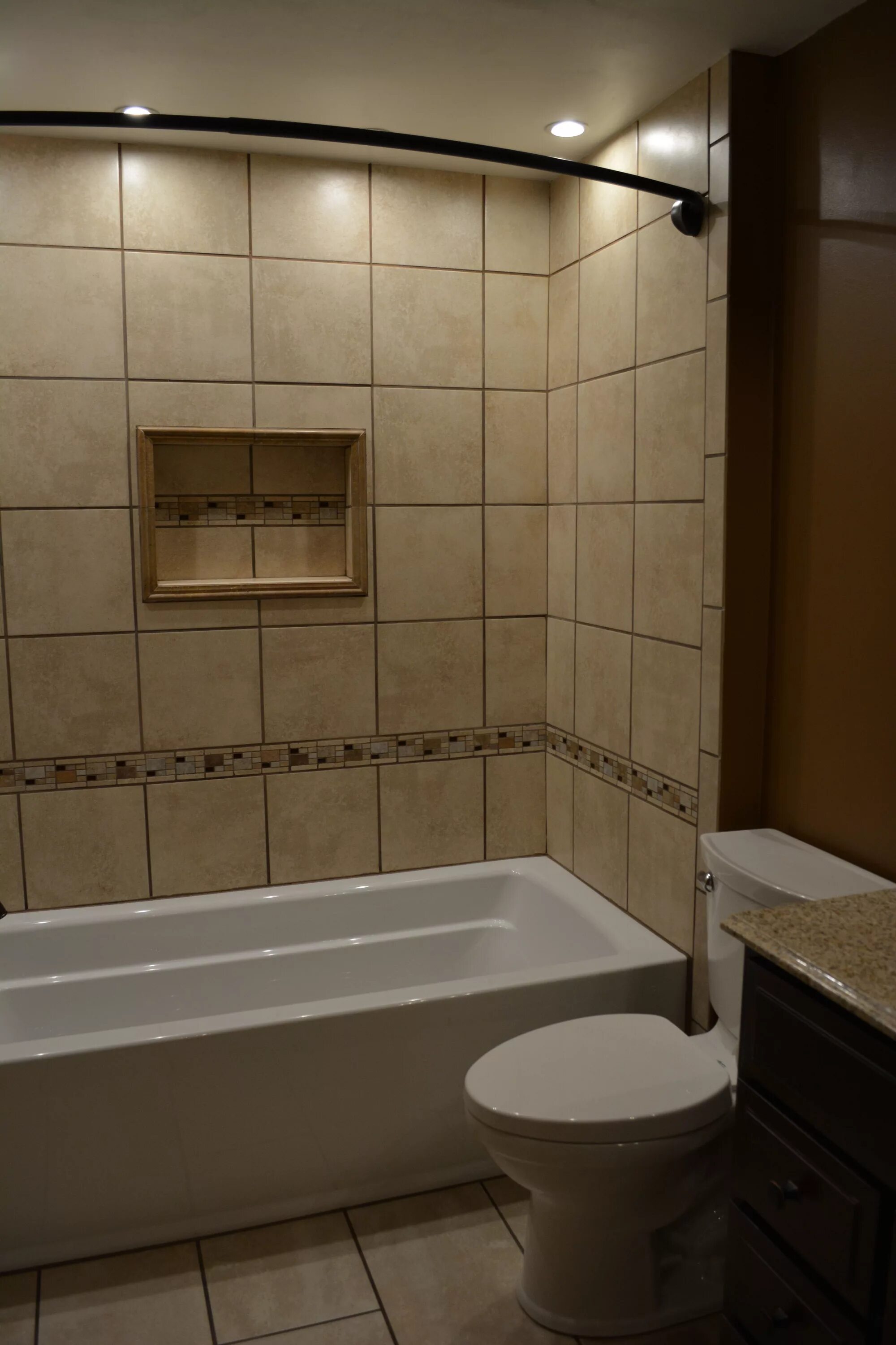 Плитка над ванной фото Ceramic tile tub surround with niche and mosaic accents, coordinating floor tile