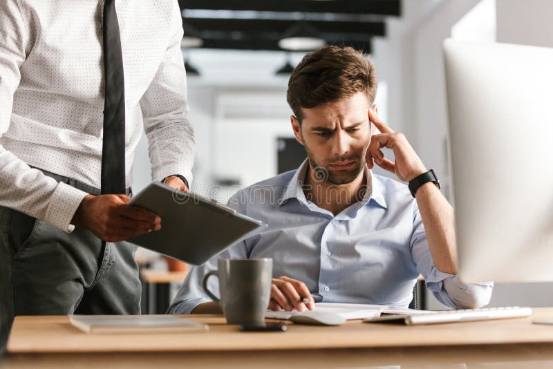 Плохой работник картинка Tired Bored Displeased Man Sitting in Office Working with Computer Near His Coll