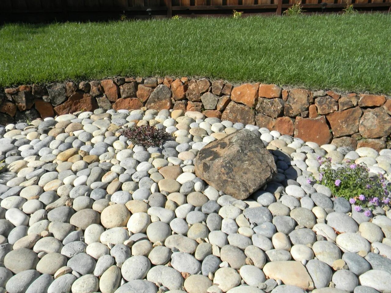 Плоский камень для ландшафтного дизайна This rounded smooth hard surface rock comes from the rivers of the Sierra Nevada