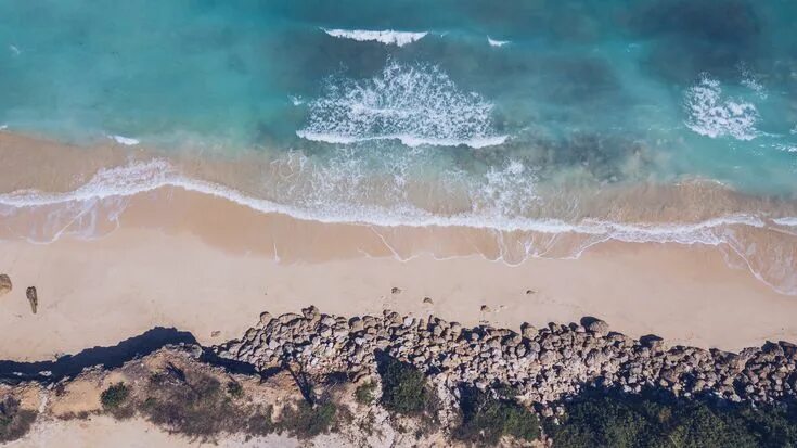 Пляж фото сверху Drone view of the ocean washing on the sand beach shore at Green Bowl Beach Most