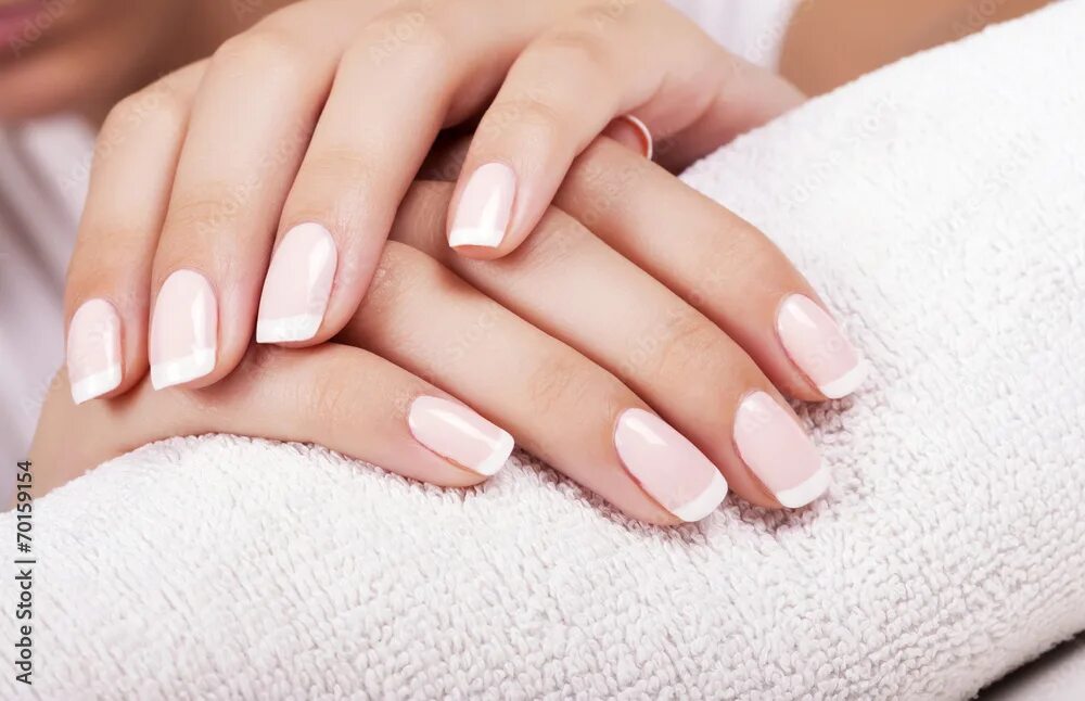Плюсы красивого маникюра Beautiful woman's nails with french manicure. Фотографія Stock Adobe Stock