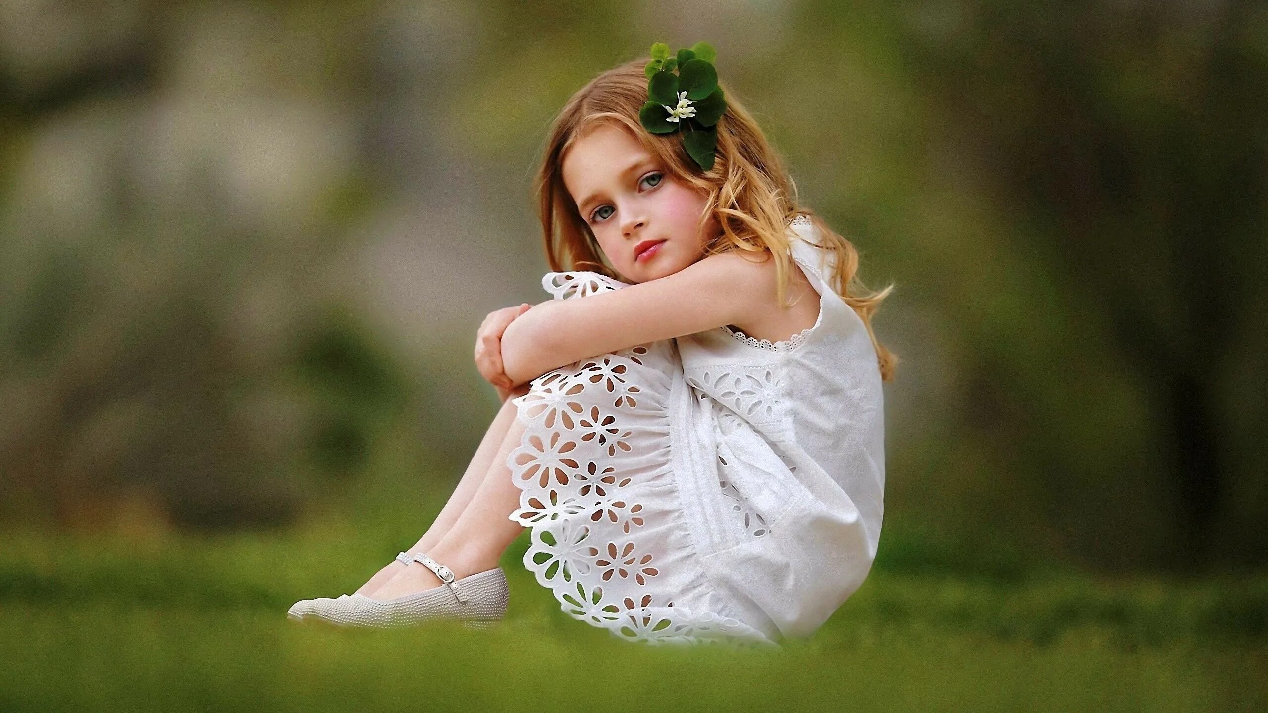 Под фото маленькой девочке Little girl in white dress is sitting on green grass Desktop wallpapers 1400x105