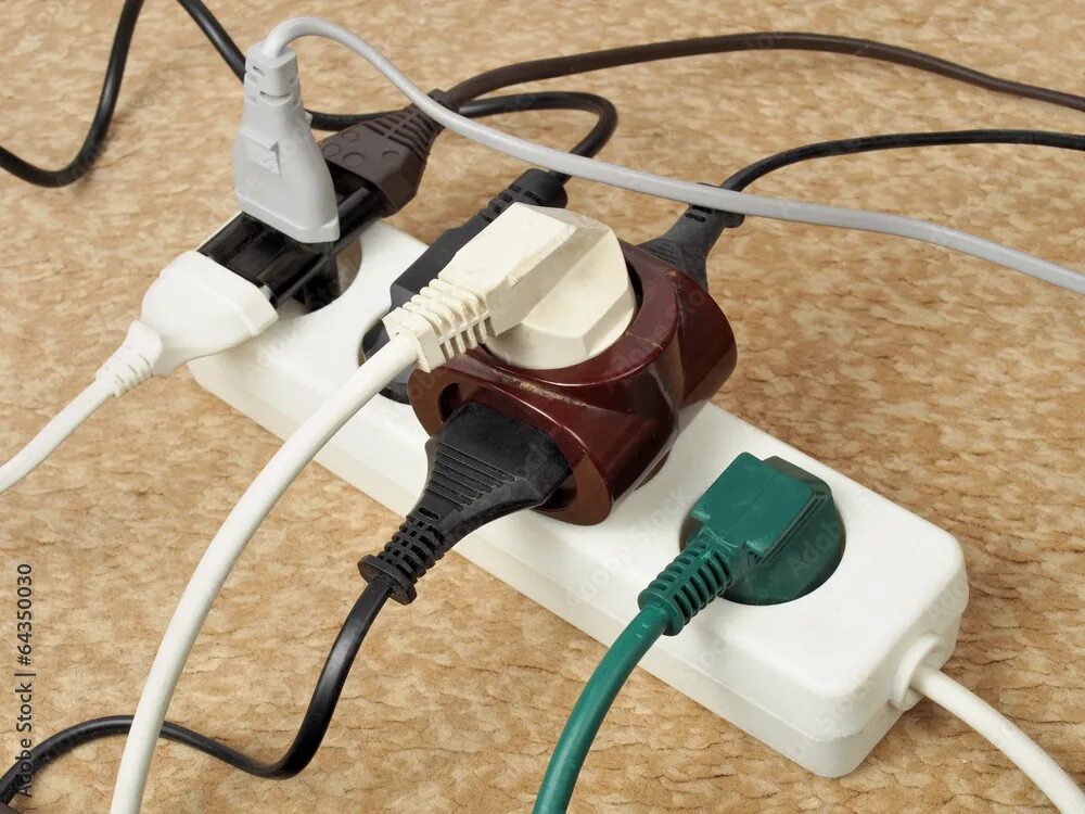 Подключение дополнительных электроприборов в розетку запрещено Overloaded extension cord фотография Stock Adobe Stock