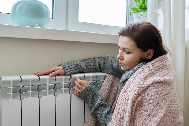 Подключение отопления череповец 2024 Winter, Heating Season. Woman in Warm Sweater Sitting in Home Room Near Heating 