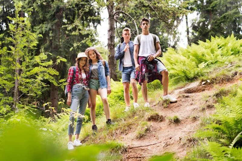 Подростки в лесу фото Teenagers with Backpacks Hiking in Forest. Summer Vacation. Stock Image - Image 