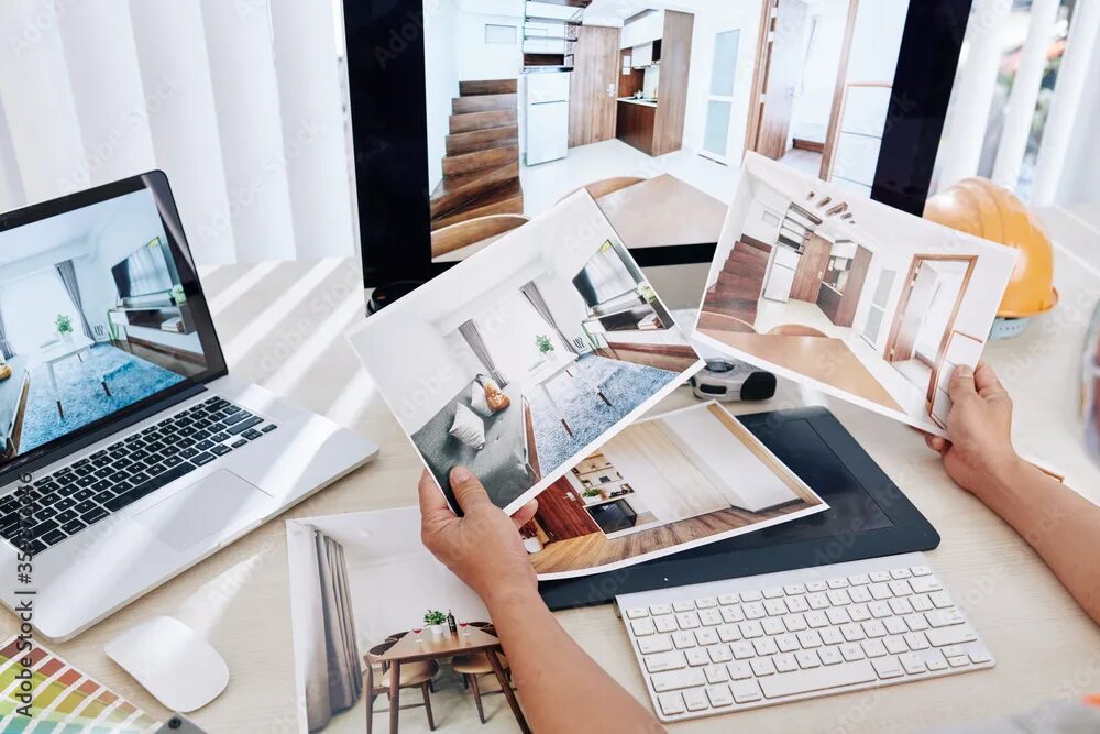 Поиск дизайнера интерьера Interior designer sitting at desk and looking at printed photos of clients rooms