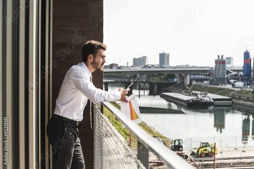 Пока я на балконе ты листаешь фото Young businessman standing on balcony looking at view Stock Photo Adobe Stock