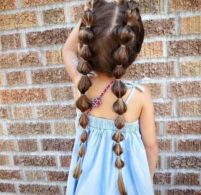 Посмотреть прически для девочек many rubber hairbands, decorating the two long pigtails, of a small child, in a 