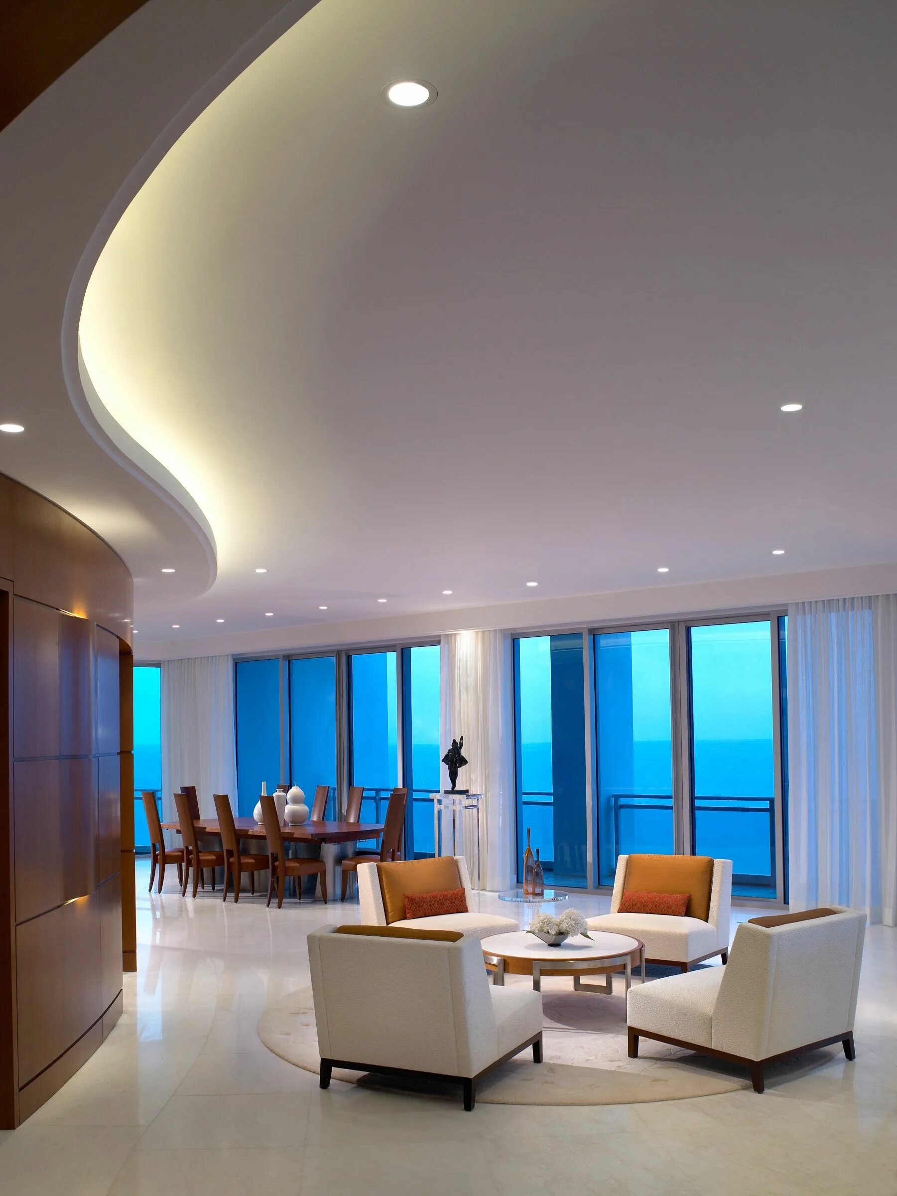 Потолки натяжные фото мода A curved ceiling and wood feature wall complement the ocean waves in the lounge.