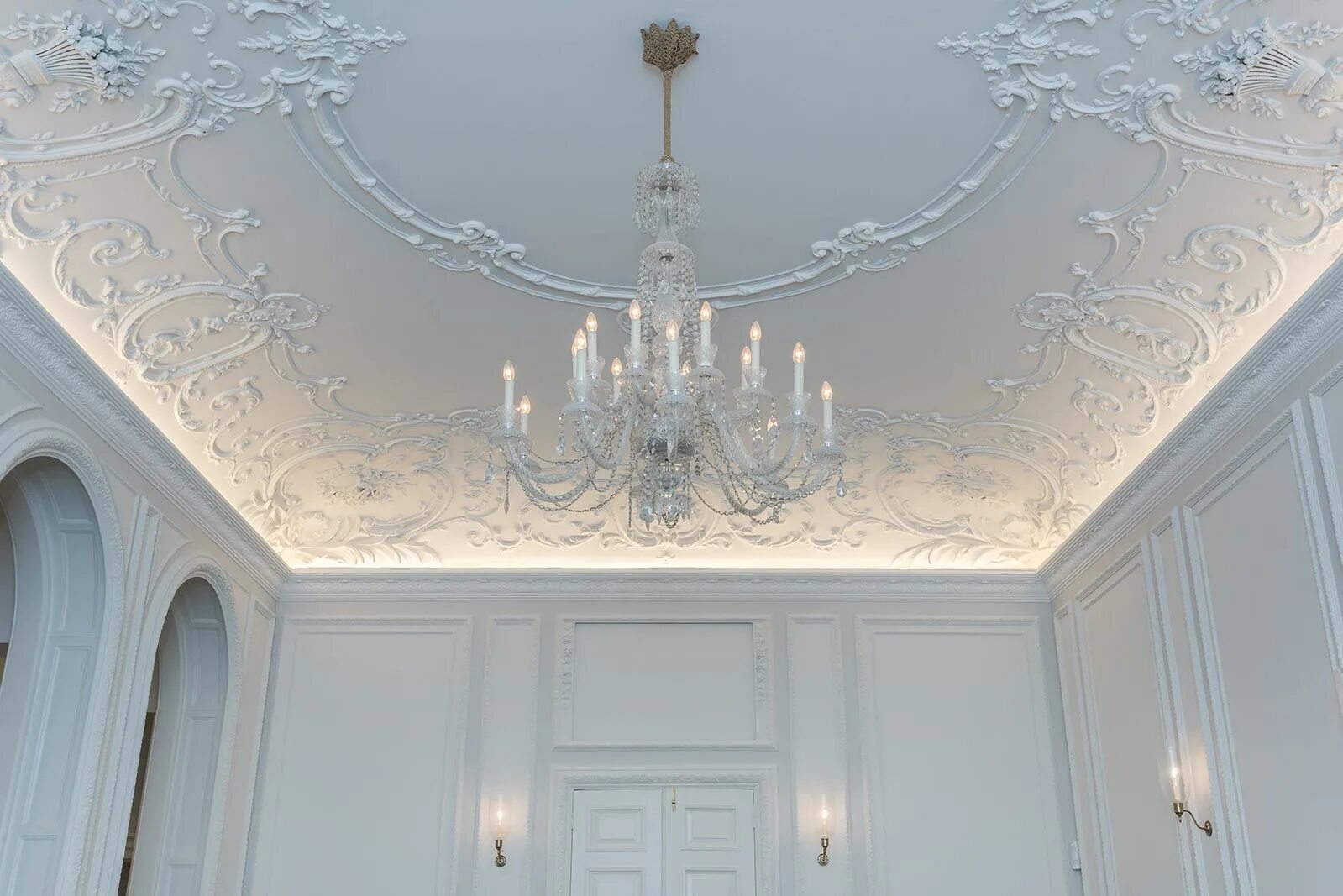 Потолок с лепниной в современном интерьере The giant white chandelier brings focus to the architrave and patterns of the ce