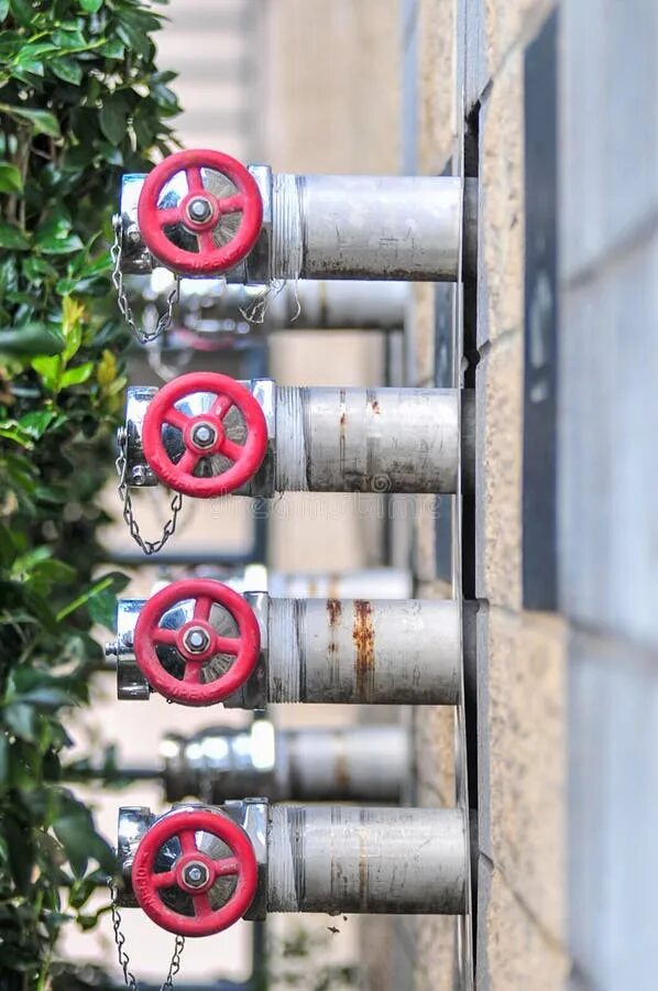 Пожарники для подключения газа Multiple Fire Department Connections on a Building Wall Stock Photo - Image of n