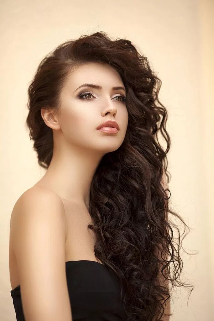 Прическа для кудрявых волос женская длинные Outdoor shot of young beautiful woman on light background.... Long curly haircut