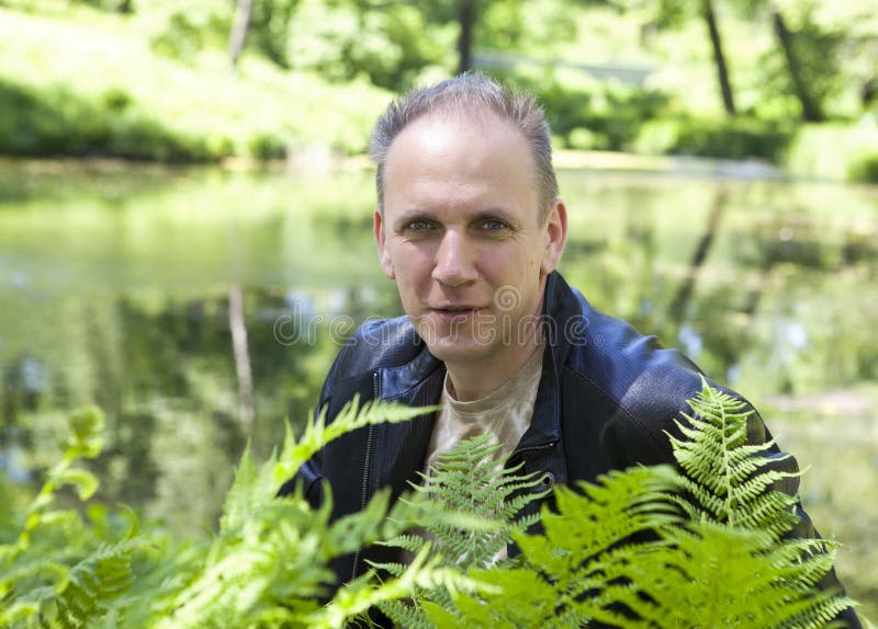 Прическа озеро в лесу мужская фото Summer Portrait of the Mature Man through Fern Leaves on a Background of the For