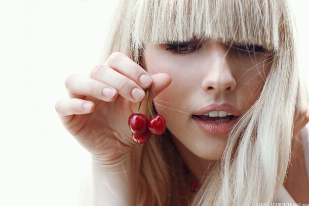 Прическа вишня Premium Photo Blond woman holding cherries