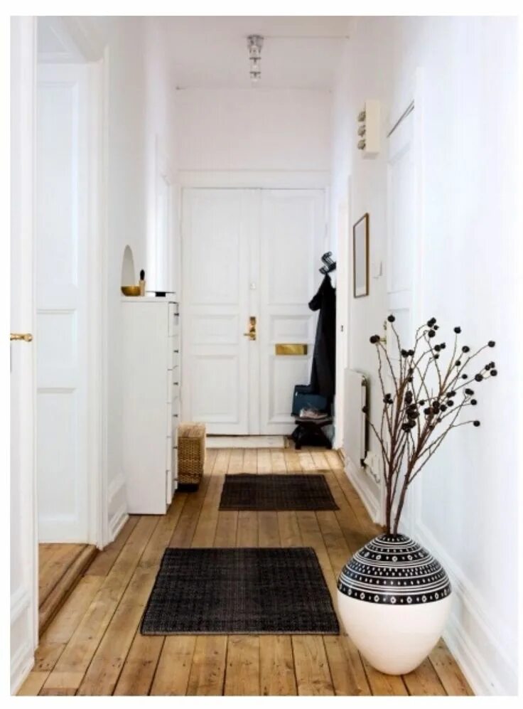 Прихожая белые стены интерьер Long hallway with more small carpets create stations for a longer room. Plants g