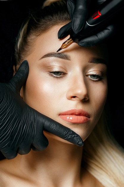 Про татуаж Premium Photo Closeup shot of a beautician in black gloves applying permanent ey