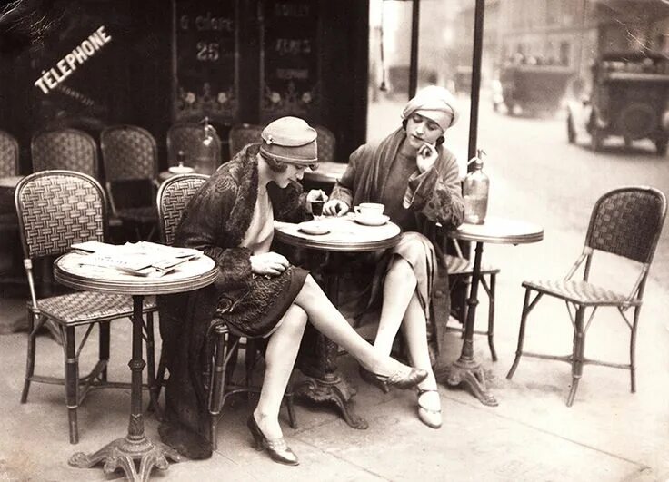 Прошлое ретро фото "Young women sitting at a café terrace, circa 1925. French postcard by Roger Vio