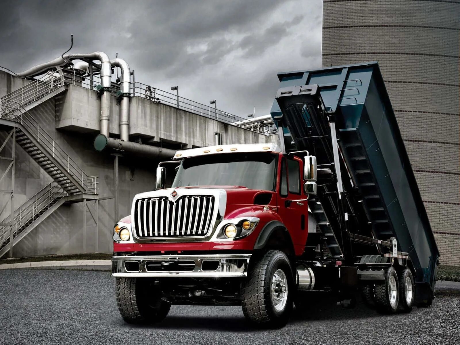 Рабочие машины фото Download A Red Dump Truck Is Parked In Front Of A Building Wallpapers.com