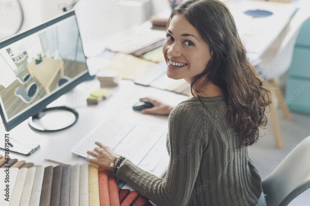 Работа дизайнером интерьера удаленно вакансии Smiling interior designer working at desk фотография Stock Adobe Stock