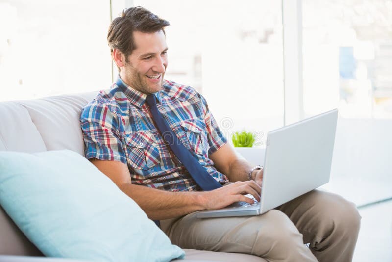 Работа лайкать фото Man using laptop on couch stock photo. Image of couch - 47023074