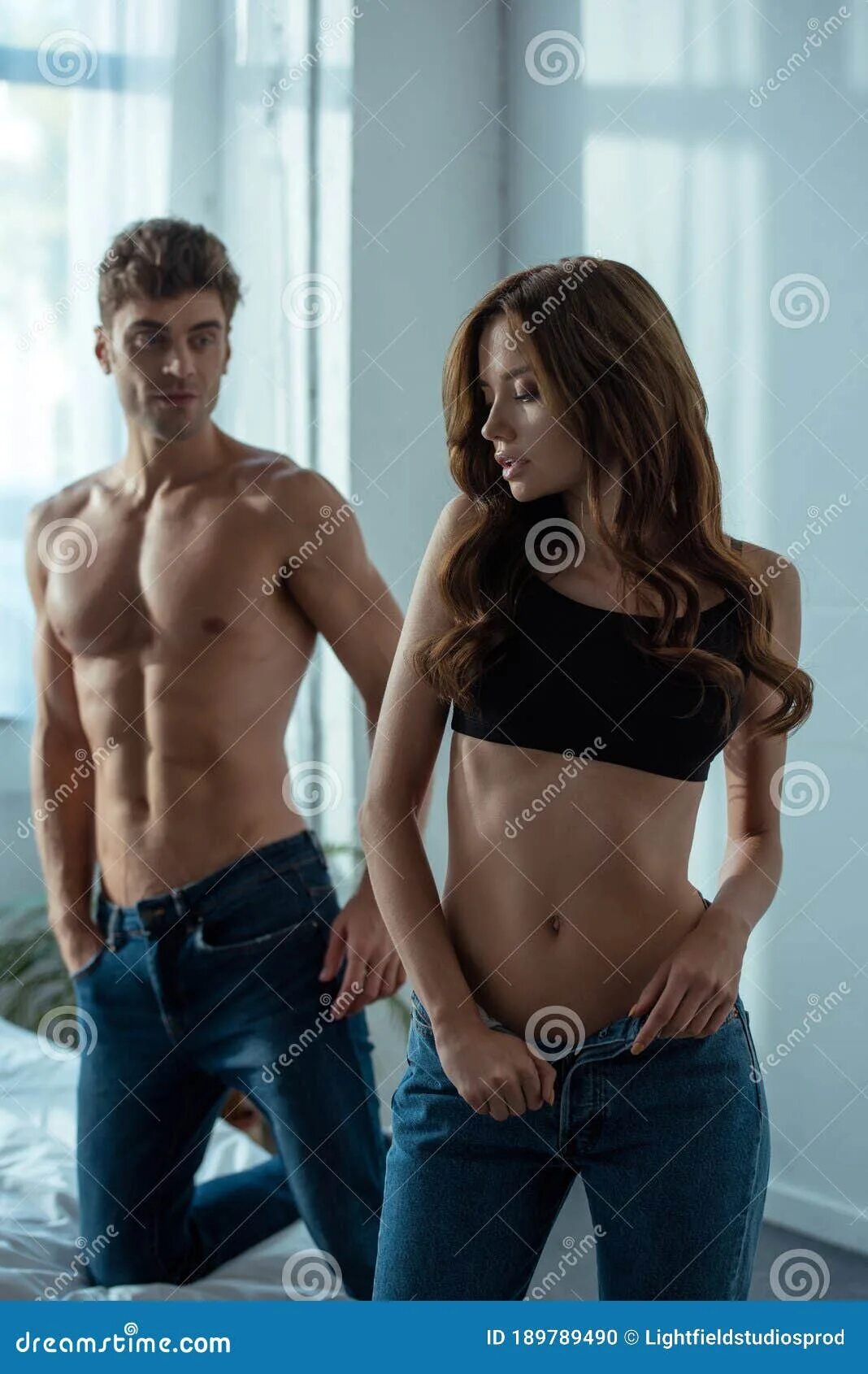 Раздеть девушку по фото лучшее бесплатно Focus of Attractive Girl Undressing in Bedroom Near Handsome Man Stock Photo - I