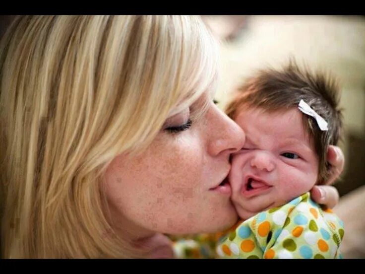 Mom kissing her little son on bed. Mother embracing infant baby. - Buy this stoc