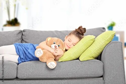 Ребенок на диване фото Little girl sleeping on couch with teddy bear Stock Photo Adobe Stock