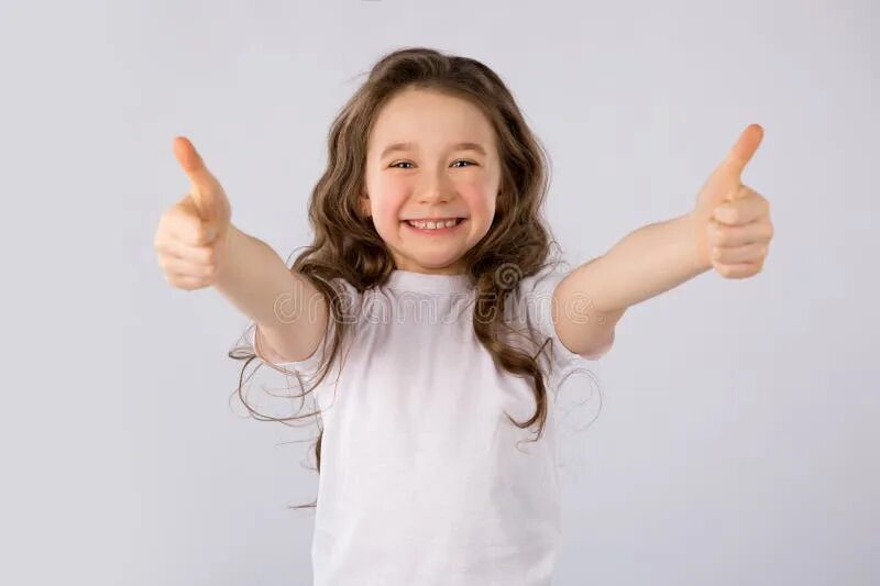 Ребенок показывает класс фото Little Girl Showing Thumbs Up Gesture in a White T-shirt Isolated on White Backg