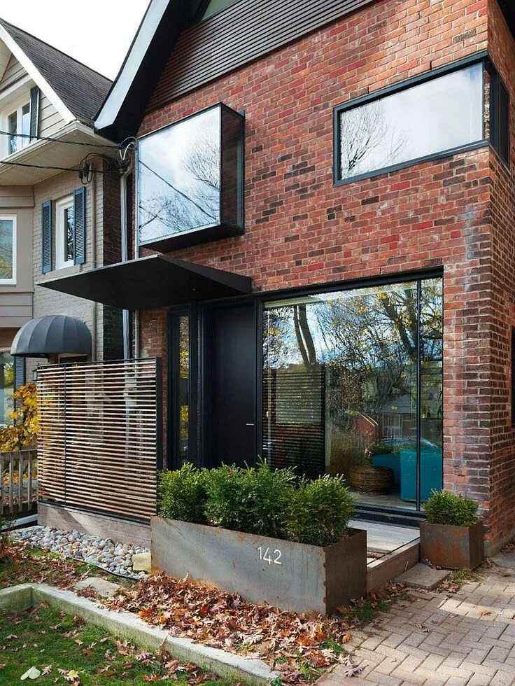 Реконструкция дома с увеличением площади оформление Early 1900s Toronto Home Charms with a Glassy Modern Renovation Brick exterior h