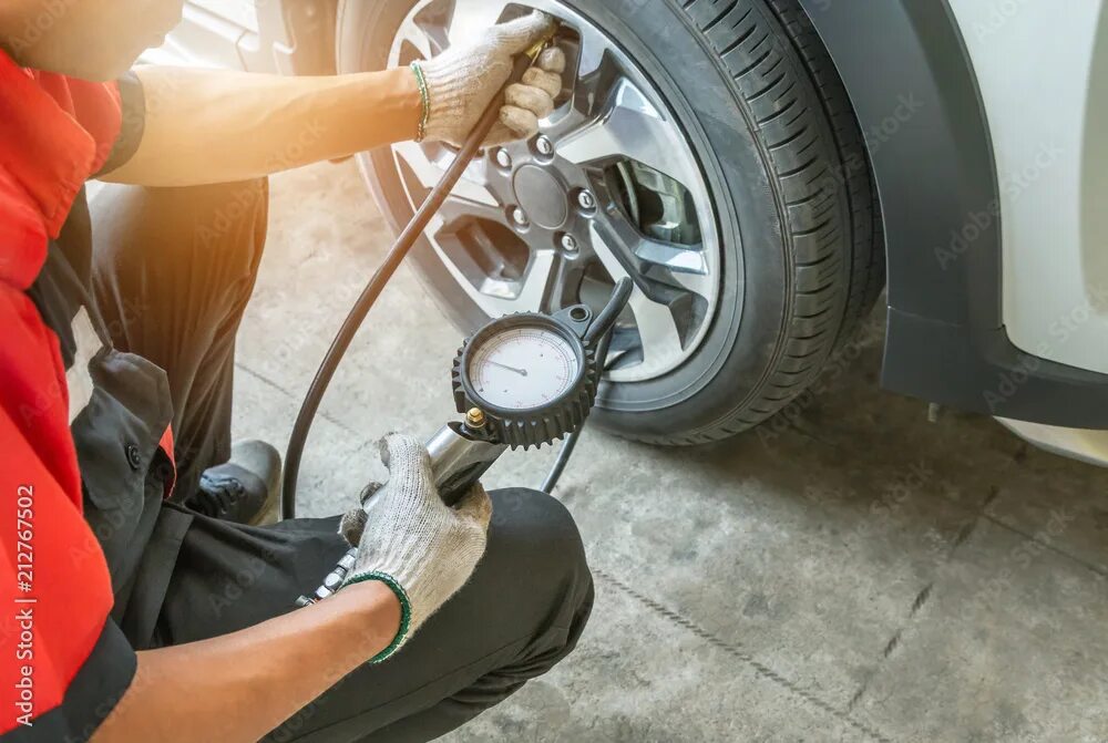 Ремонт для подкачки шин своими руками Close up mechanic inflating tire and checking air pressure with gauge pressure i