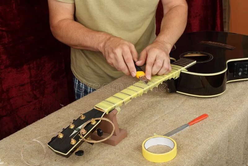 Ремонт гитары своими руками Guitar Repair and Service - Worker Preparation Pasting of Frets Stock Image - Im