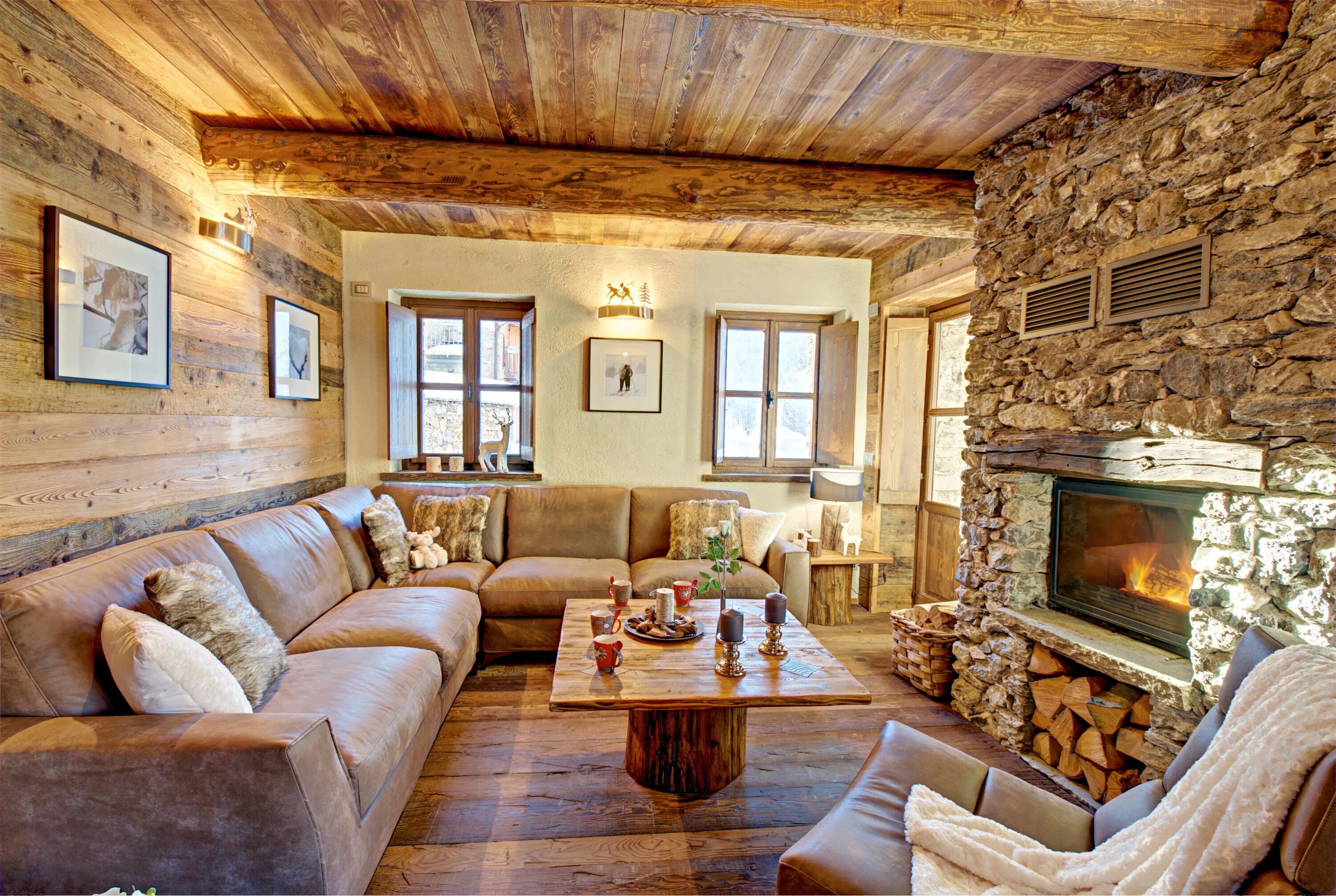 Ремонт в своем доме Ski chalet living room with leather sofa, fireplace, wooden floor and furniture,