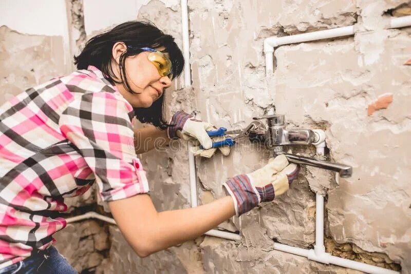 Ремонт женщина своими руками Woman repairs the pipes stock photo. Image of installing - 122538134